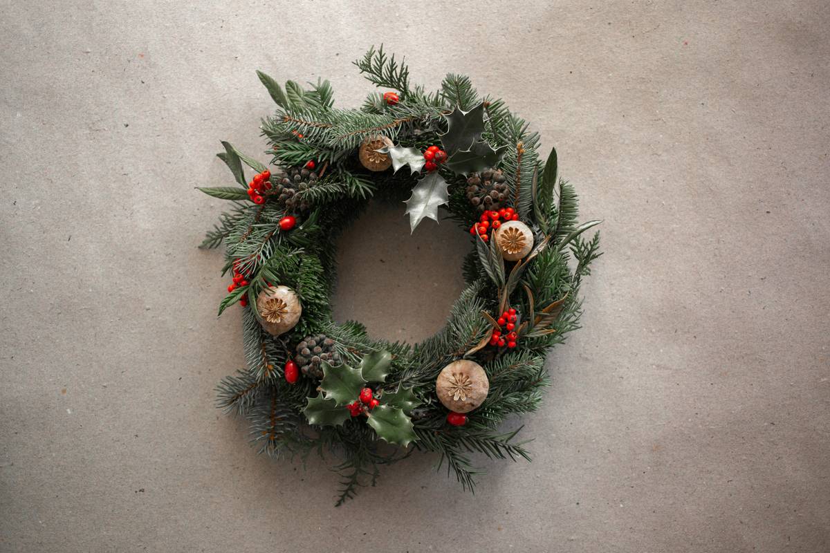 Step-by-step visual guide showing how to decorate christmas wreaths using natural materials and asymmetrical design
